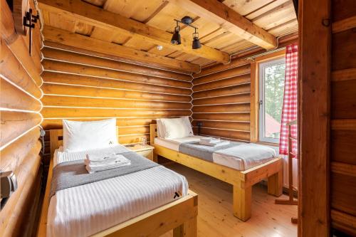 a bedroom with two beds in a log cabin at Gremi Hotel in Dragobrat