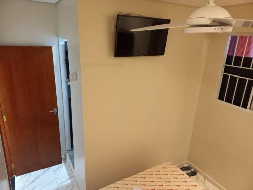 Zimmer mit einem TV an der Wand und einem Bett in der Unterkunft Hotel Avenida Brás in São Paulo