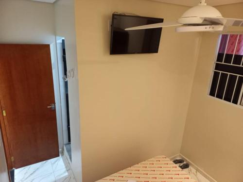 Una habitación con un televisor en la pared y una cama. en Hotel Avenida Brás, en São Paulo
