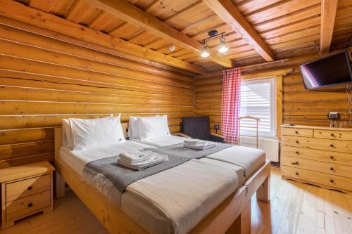 1 dormitorio con 1 cama en una cabaña de madera en Gremi Hotel, en Dragobrat