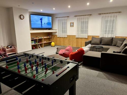 a living room with a pool table and a tv at Chata VISTA Strážné in Strážné