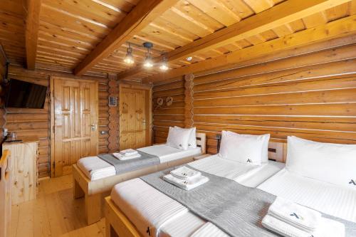 a room with two beds in a log cabin at Gremi Hotel in Dragobrat