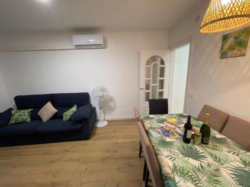 sala de estar con sofá y mesa con botellas de vino en Apartamento en la costa del Maresme, en Pineda de Mar