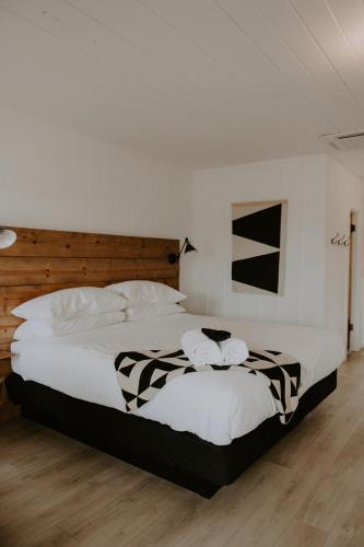 a bedroom with a large bed with black and white sheets at Triangle Motel in Red Bluff