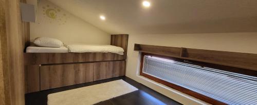 a small room with a bunk bed and a window at Apartman Uma in Sarajevo