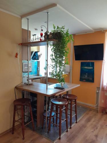 uma cozinha com uma mesa de madeira e bancos em Cozy Apartment em Alūksne