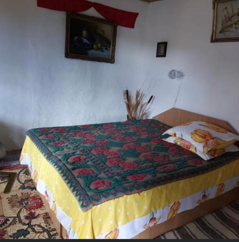 uma cama com uma colcha num quarto em Căsuța fa rai din ce ai em Buzau