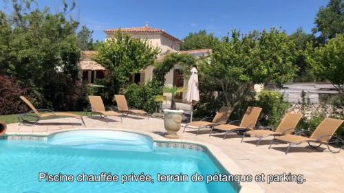 une piscine avec des chaises et une maison dans l'établissement 1832 La Rabassière - Gîte, à Malaucène