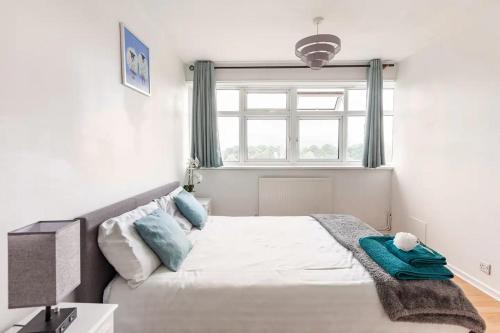 a bedroom with a large bed with a window at Spacious Room by Lee Valley White Water Centre. Waltham Cross in Waltham Cross