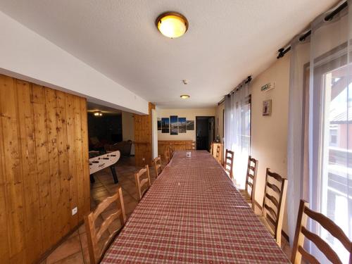 - un long couloir dans une pièce avec une table et des chaises dans l'établissement Chalet de Luxe 6 Chambres, Proche Pistes avec WiFi, Babyfoot et Cheminée - FR-1-266-184, à Montgenèvre