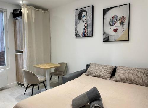 ノワジー・ル・セックにあるLe P'tit Paris - Studio 2 personnes proche Parisのベッドとテーブルと椅子のある寝室