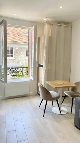 une pièce avec une table, une chaise et une fenêtre dans l'établissement Le P'tit Paris - Studio 2 personnes proche Paris, à Noisy-le-Sec