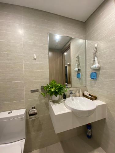 uma casa de banho com um lavatório, um espelho e um WC. em Blue Ocean Homestay em Hanói