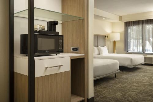 a hotel room with a television and two beds at SpringHill Suites Fort Worth University in Fort Worth