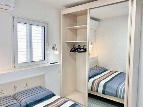 a small bedroom with two beds and a mirror at Seaside cozy apartment in Haifa