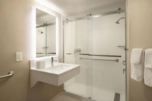 a white bathroom with a sink and a shower at SpringHill Suites Fort Worth University in Fort Worth