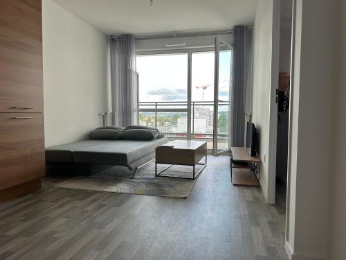 een slaapkamer met een bed en een groot raam bij Agréable 2 pièces avec balcon et Parking transports by immo kit bnb in Sarcelles