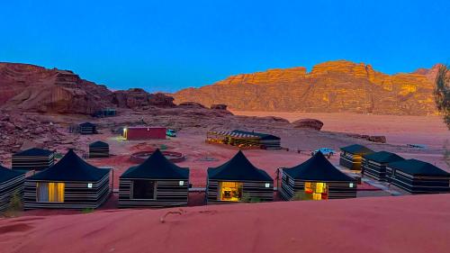 a group of huts in the middle of the desert at STARDUSt CAMP in Wadi Rum