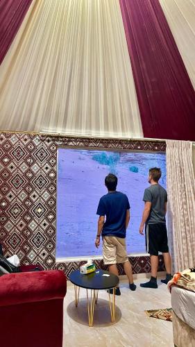 two men standing in a tent playing a video game at RUM STARDUST lUXURY CAMP in Wadi Rum