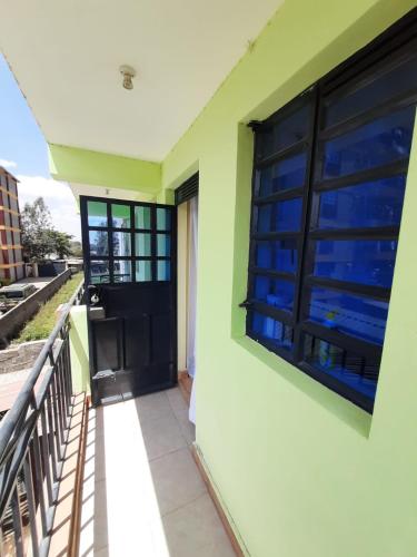 balcón con puerta negra y ventana en Lymak Studio airbnb en Ongata Rongai 