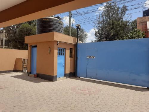 a blue building with a barrel on top of it at Lymak Studio airbnb in Ongata Rongai 