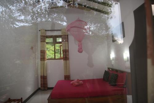 a bedroom with a red bed and a window at Rivinu Holiday Resort in Ella
