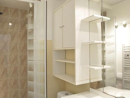 La salle de bains est pourvue d'armoires blanches et d'une douche. dans l'établissement Studio rénové au Cap d'Agde : 4 couchages, clim, proche plage et port, parking à proximité - FR-1-249-351, au Cap d'Agde