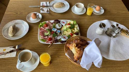 einen Holztisch mit Teller mit Speisen und Eiern in der Unterkunft Pension Berta in Waidring
