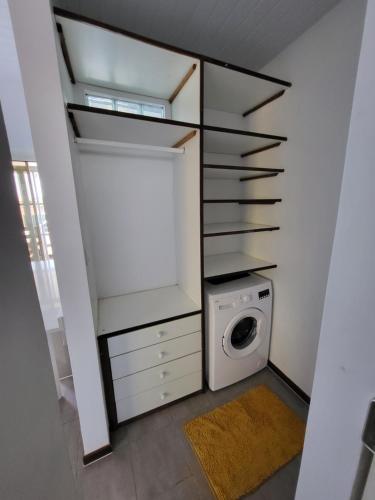 a laundry room with a washing machine and a washer at LocaGuyane in Matoury