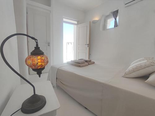 a bedroom with a bed with a lamp next to it at Καμάρα (Kamara) cave rooms in Triovasálos