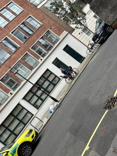 un hombre montando una bicicleta por una calle al lado de un edificio en Victoria en Londres