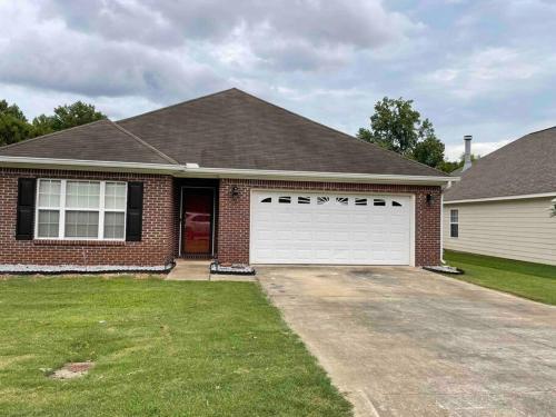 une maison en briques avec un garage blanc dans l'établissement Prattville Delight*Jacuzzi Tub*+Central Location*, à Prattville