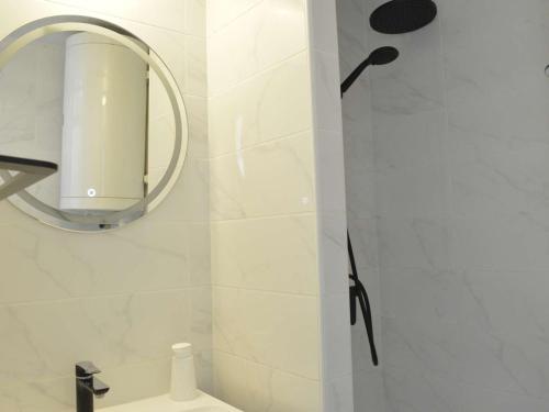 La salle de bains est pourvue d'une douche avec un miroir et un lavabo. dans l'établissement Studio cabine 4 pers, Cap d'Agde, proche port - FR-1-249-360, au Cap d'Agde