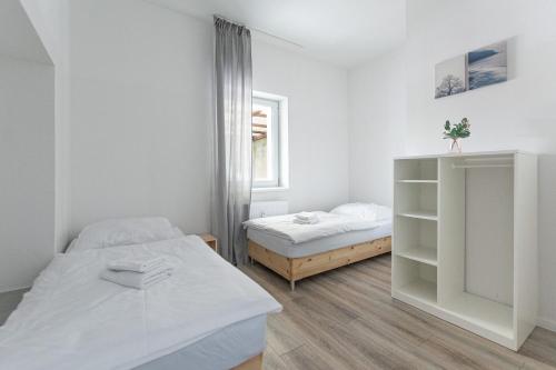 Habitación blanca con 2 camas y ventana en T&K Apartments - 1 to 4 Room Apartments - 20min to TradeFair Messe Airport Düsseldorf, en Duisburg