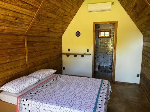 a bedroom with a bed in a wooden room at Pousada Sossego do Tocantins in Lajeado