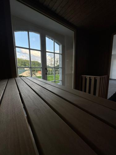 a large wooden table in a room with a window at Ferienwohnung Blick Thyratal Obergeschoss in Stolberg i. Harz