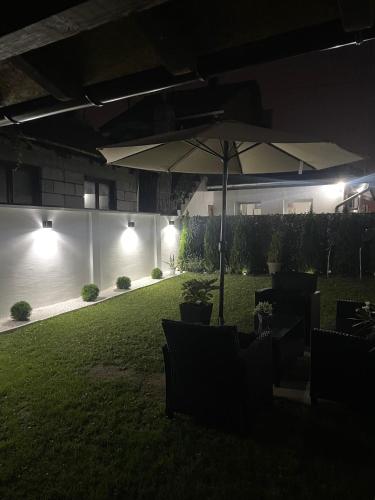 a patio with an umbrella in a yard at night at Stari grad 2 in Valjevo