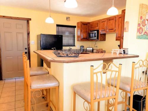 a kitchen with a island with two chairs and a counter top at White Sands Casita in Alamogordo