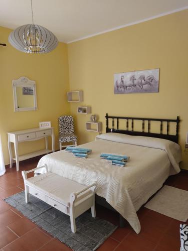 1 dormitorio con 1 cama grande y 1 mesa en Domo Is Domus en SantʼAnna Arresi