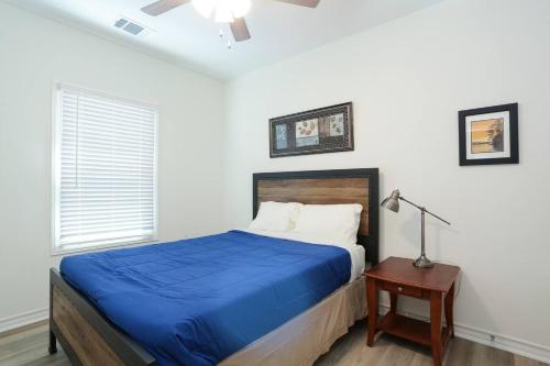 - une chambre avec un lit doté d'une couverture bleue et d'une table dans l'établissement Modern & Furnished Home near Downtown & Fort Sam, à San Antonio