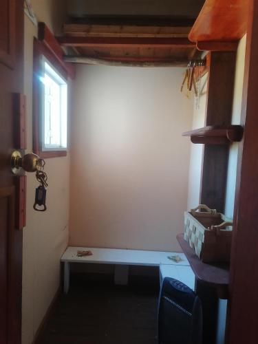 a room with a bench in a room with a window at Habitación tipo Loft de la Estancia in El Quisco