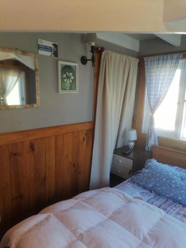 1 dormitorio con cama, espejo y ventana en Habitación tipo Loft de la Estancia en El Quisco
