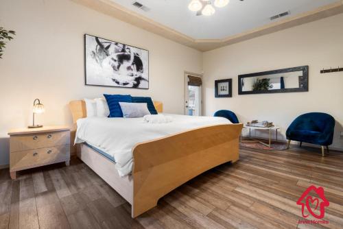 a bedroom with a large bed with blue pillows at Desert Hills - An Irvie Home in Albuquerque