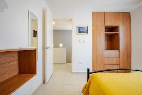 een slaapkamer met een geel bed en een kast bij Estrena casa a minutos del aeropuerto in Monterrey