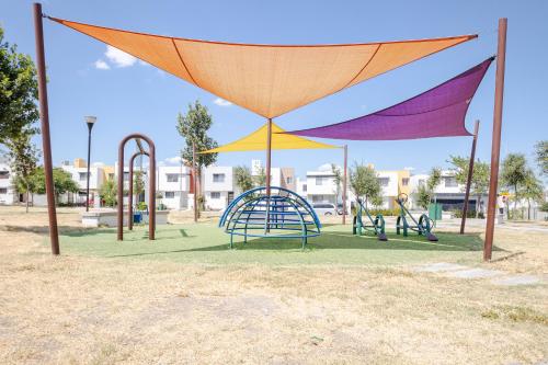 a playground with colorful swings and slides in a park at Estrena casa a minutos del aeropuerto in Monterrey