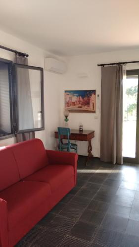 a living room with a red couch and a table at Avocado B&B Beyond in Giardini Naxos