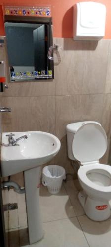 a bathroom with a white toilet and a sink at Palcos Hostal in Quito