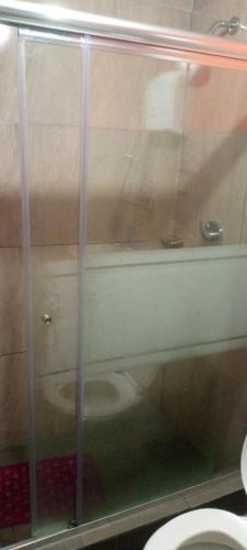 a glass shower in a bathroom with a toilet at Palcos Hostal in Quito