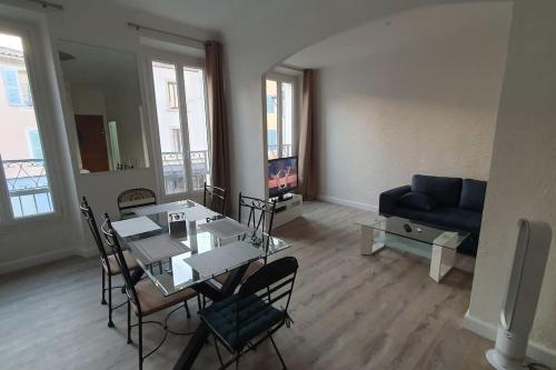 un salon avec une table, des chaises et un canapé dans l'établissement Appartement centre-historique 70 m2, à Fréjus