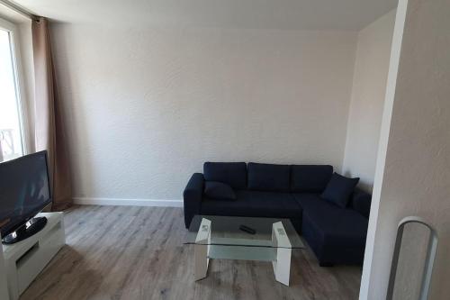 Sala de estar con sofá azul y mesa de centro en Appartement centre-historique 70 m2 en Fréjus